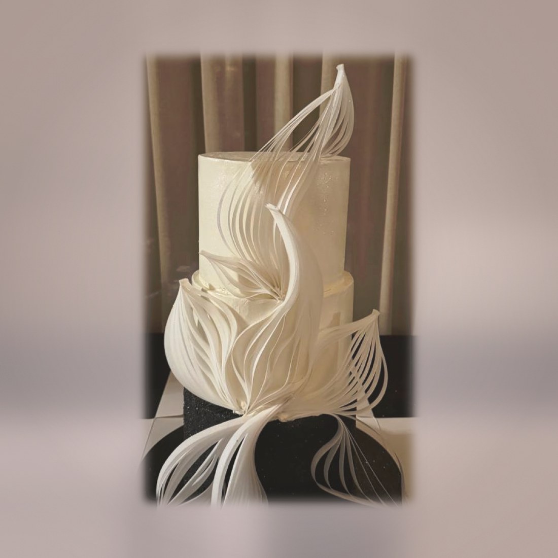 Sculptural white wedding cake with sugar feathers
