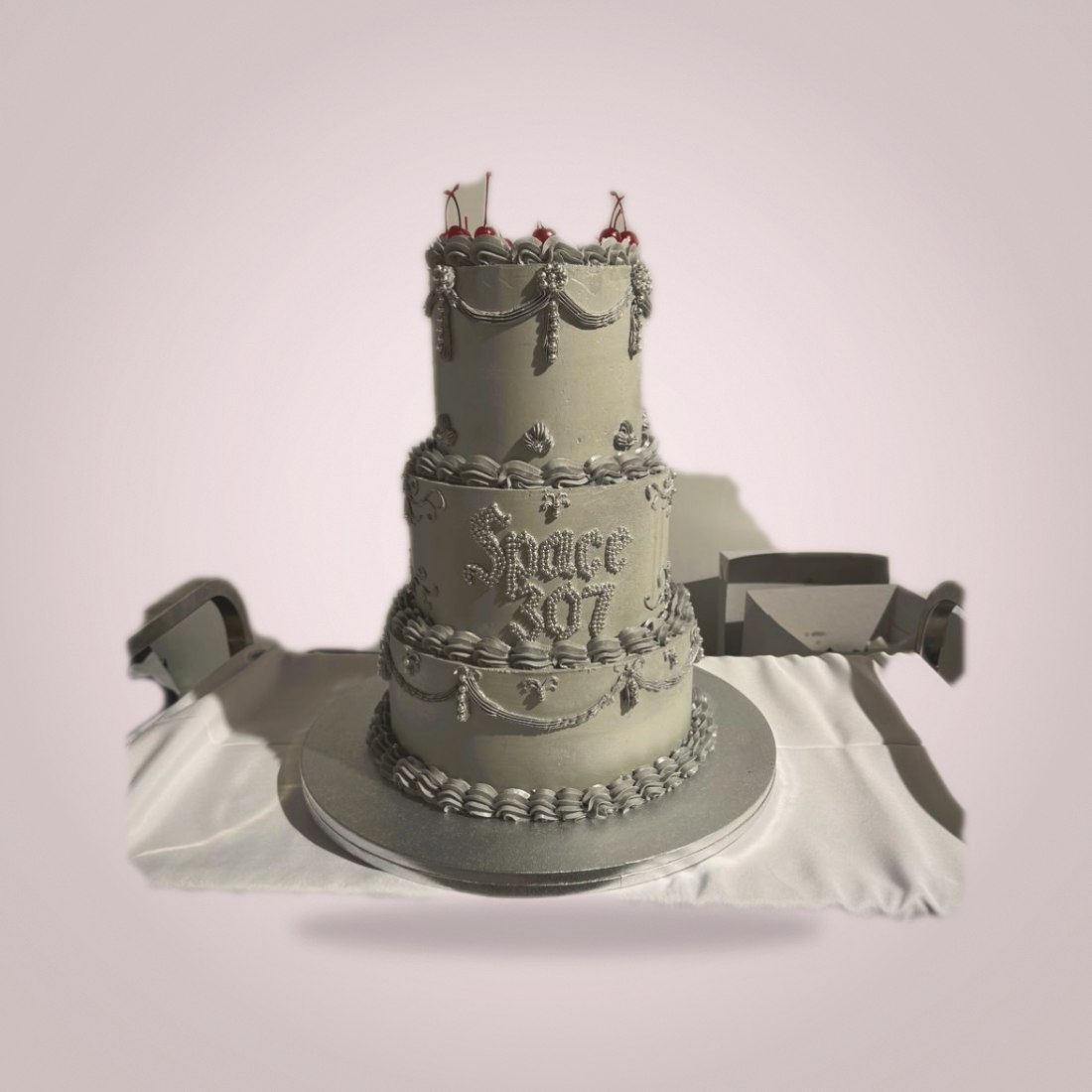 Silver three-tier vintage-style cake with cherries